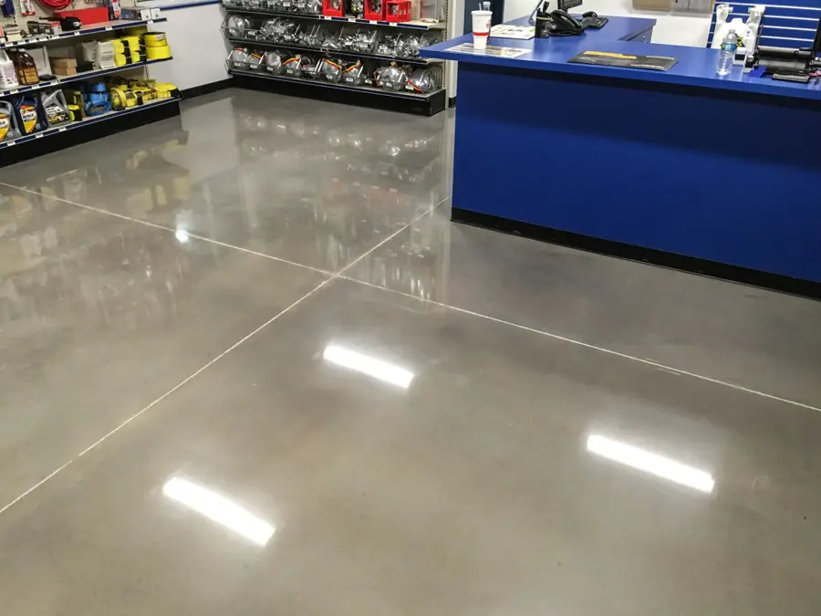 A polished concrete floor reflecting overhead lights in a retail space