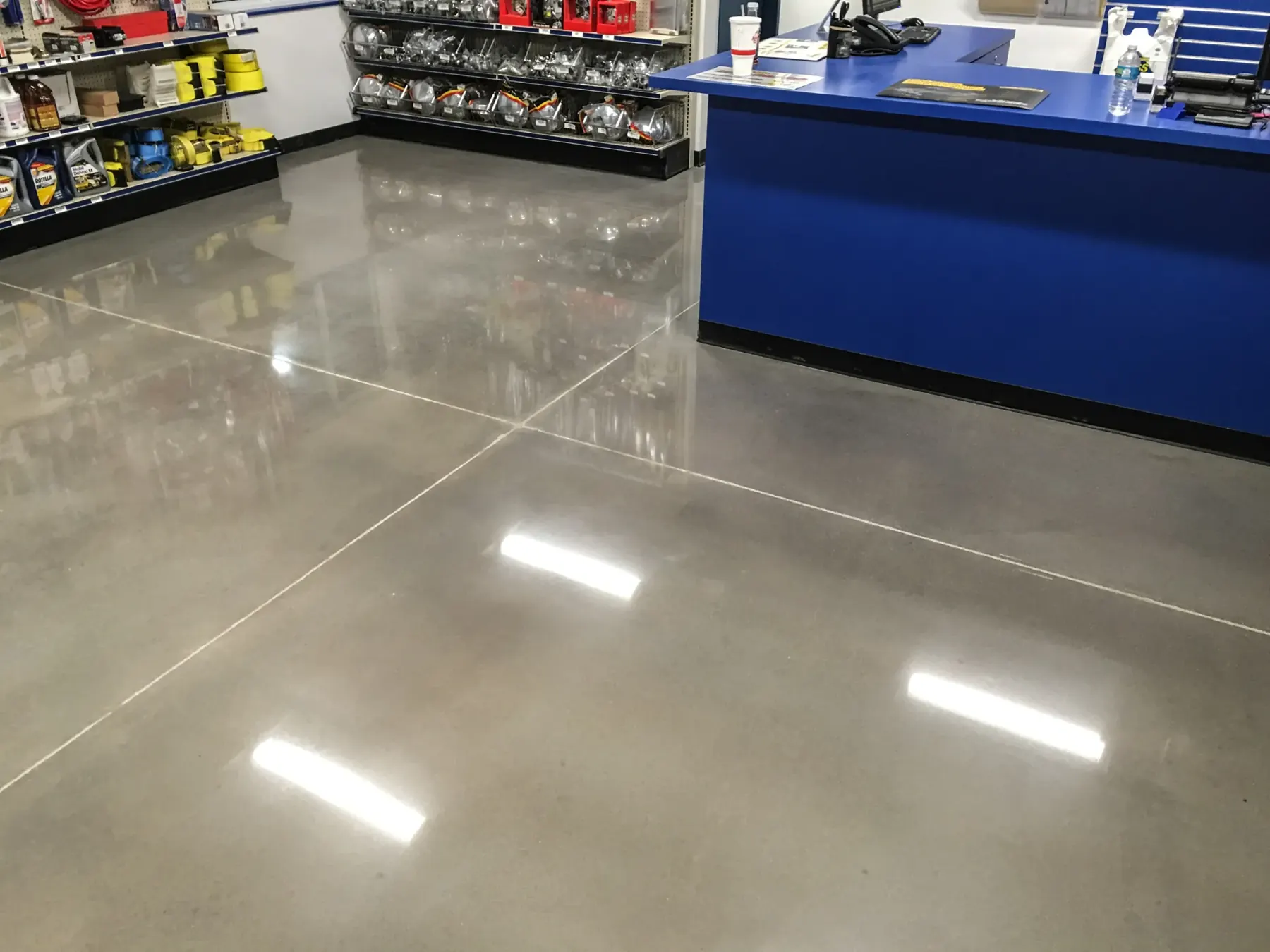 A polished concrete floor reflecting overhead lights in a retail space
