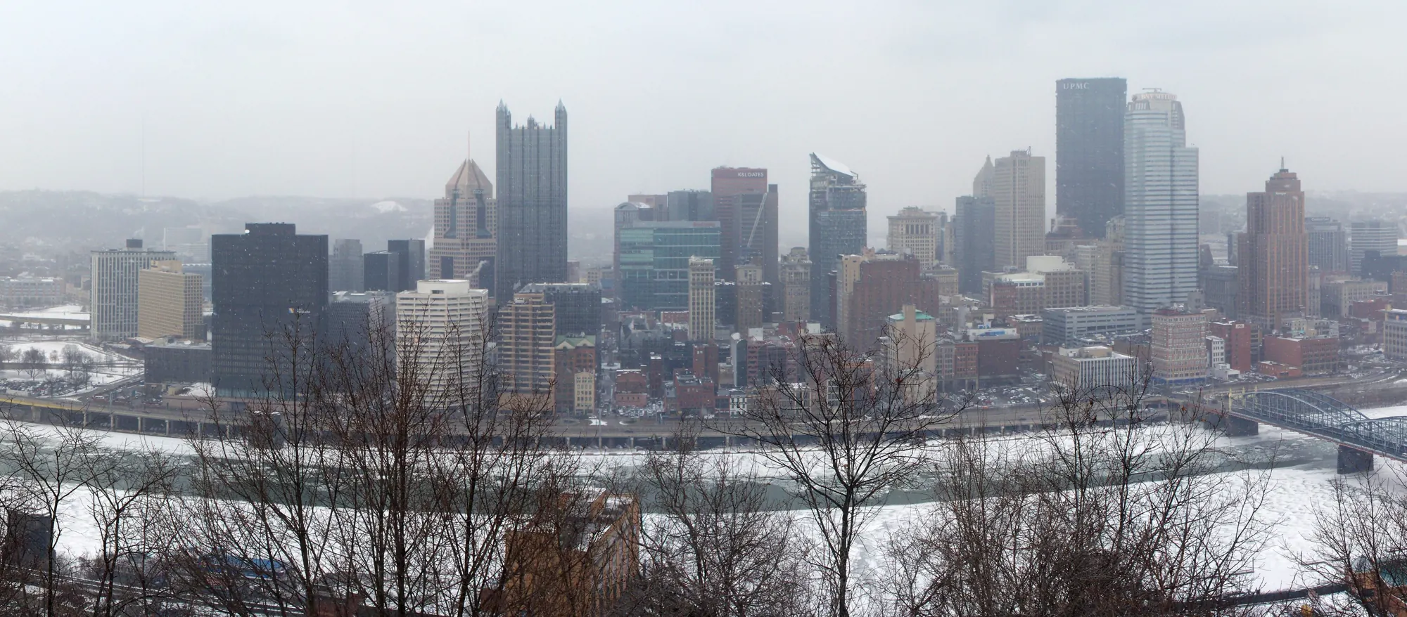 Snow falling on downtown Pittsburgh, with iced rivers and the Smithfield Street Bridge, seen from Mount Washington