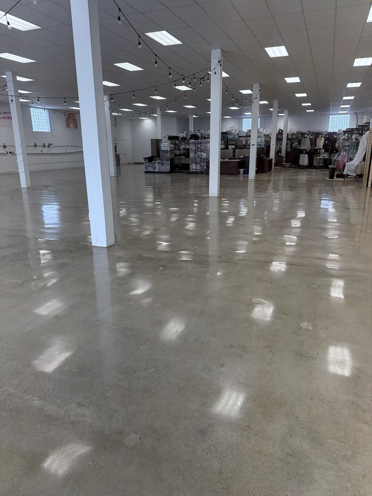 Open commercial room, polished floor and a white column in the foreground, merchandise racks in the background, Pittsburgh area.